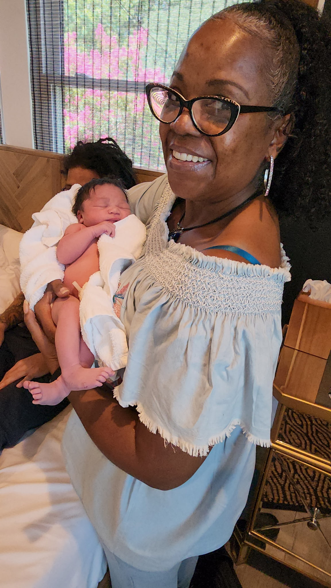 Grandmother holding newborn — generational welcoming